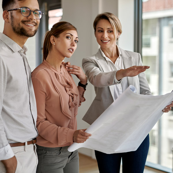 woman looking at blueprint with clients